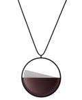 The Clara necklace in cognac resin embodies clarity and balance. Named from the Latin clarus, meaning “bright” or “clear,” it reflects the quiet harmony of light and material. Within the circular frame, concrete emerges from the surface of the resin, creating a gentle rise in tone and texture. The Clara necklace carries a calm, sculptural presence that feels both modern and enduring.
