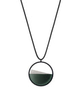 The Clara Small necklace in Cypress green resin captures the essence of clarity in a refined, understated form. Named from the Latin clarus, meaning “bright” or “clear,” it reveals a quiet balance between resin and concrete. Within the circular frame, the concrete emerges gently from the resin’s surface, creating a soft meeting of tone and texture. Subtle and luminous, the Clara Small necklace offers a delicate expression of modern minimalism.