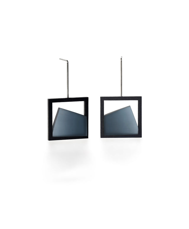 The Isla earrings highlight the beauty of light captured in resin. Each earring features a smooth gradient that shifts softly from light to dark, creating a subtle sense of depth and movement. The translucent resin reflects and diffuses light with every angle, adding a quiet luminosity to the geometric form. Elegant and modern, these earrings bring a refined balance of contrast and calm to any look. IN CERULEAN BLUE