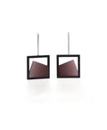 The Isla earrings highlight the beauty of light captured in resin. Each earring features a smooth gradient that shifts softly from light to dark, creating a subtle sense of depth and movement. The translucent resin reflects and diffuses light with every angle, adding a quiet luminosity to the geometric form. Elegant and modern, these earrings bring a refined balance of contrast and calm to any look. in cognac resin