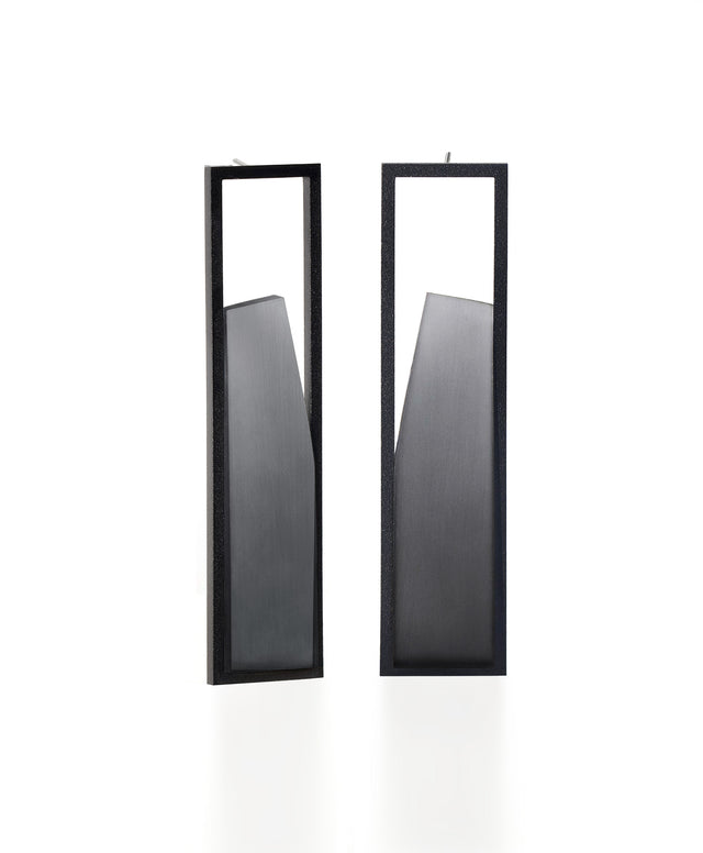 The Lucia earrings feature a sculptural interplay of shadow and light within a sleek rectangular frame. As the wearer moves, the translucent insets shift in tone deepening and softening with a turn of the head. Their geometric form captures a quiet elegance, embodying the Lumina Collection’s exploration of contrast and depth. A refined statement piece that is guaranteed to draw the eye.