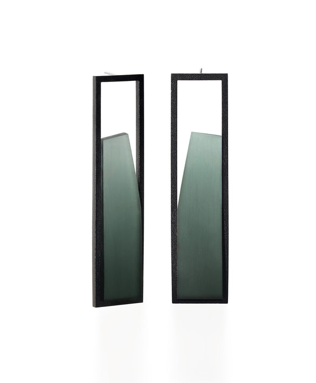 The Lucia earrings feature a sculptural interplay of shadow and light within a sleek rectangular frame. As the wearer moves, the translucent insets shift in tone deepening and softening with a turn of the head. Their geometric form captures a quiet elegance, embodying the Lumina Collection’s exploration of contrast and depth. A refined statement piece that is guaranteed to draw the eye. available in cypress.