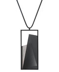 The Naia necklace in Ash grey embodies the feeling of wearing a work of art. Within its black rectangular frame, layers of resin and concrete are composed with sculptural precision, creating depth and quiet movement. The graduated tone of the resin shifts gently with the light, giving the piece a quiet, sculptural presence. Balanced and distinctive, the Naia necklace transforms simple geometry into a refined expression of wearable art.