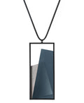The Naia necklace embodies the feeling of wearing a work of art. Within its black rectangular frame, layers of resin and concrete are composed with sculptural precision, creating depth and quiet movement. The graduated tone of the resin shifts gently with the light, giving the piece a quiet, sculptural presence. Balanced and distinctive, the Naia necklace transforms simple geometry into a refined expression of wearable art.