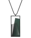 The Naia necklace in Cypress green embodies the feeling of wearing a work of art. Within its black rectangular frame, layers of resin and concrete are composed with sculptural precision, creating depth and quiet movement. The graduated tone of the resin shifts gently with the light, giving the piece a quiet, sculptural presence. Balanced and distinctive, the Naia necklace transforms simple geometry into a refined expression of wearable art.