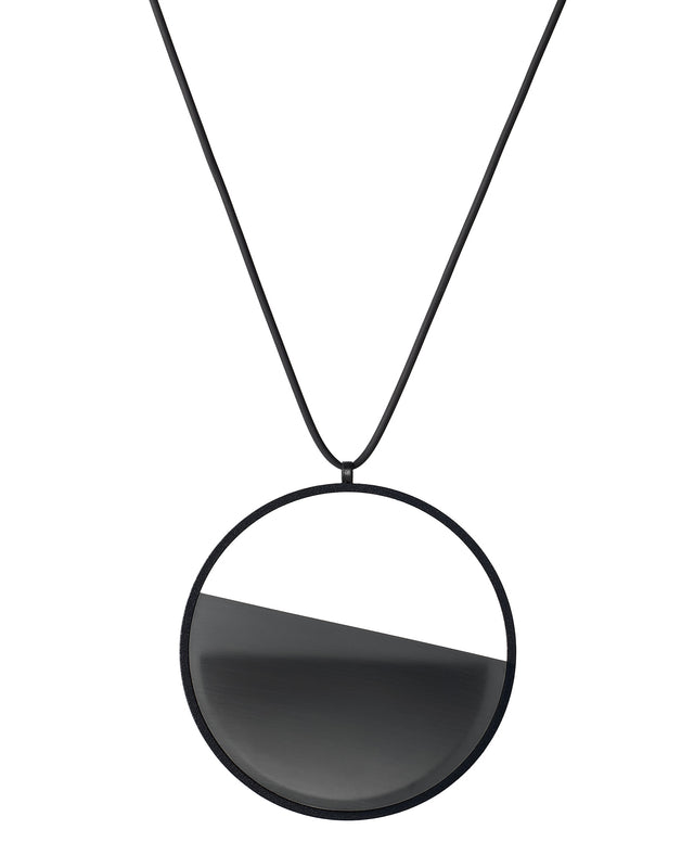 The Vestra necklace in Ash grey embodies balance and quiet strength. Its name, derived from the Latin vestra, meaning “yours,” speaks to a personal connection between wearer and form. Within the circular frame, concrete is cast into resin revealing a smooth plane of depth and tone, reflecting light in a soft, fluid way. The composition feels calm and grounded, offering a sculptural presence that becomes uniquely individual when worn.