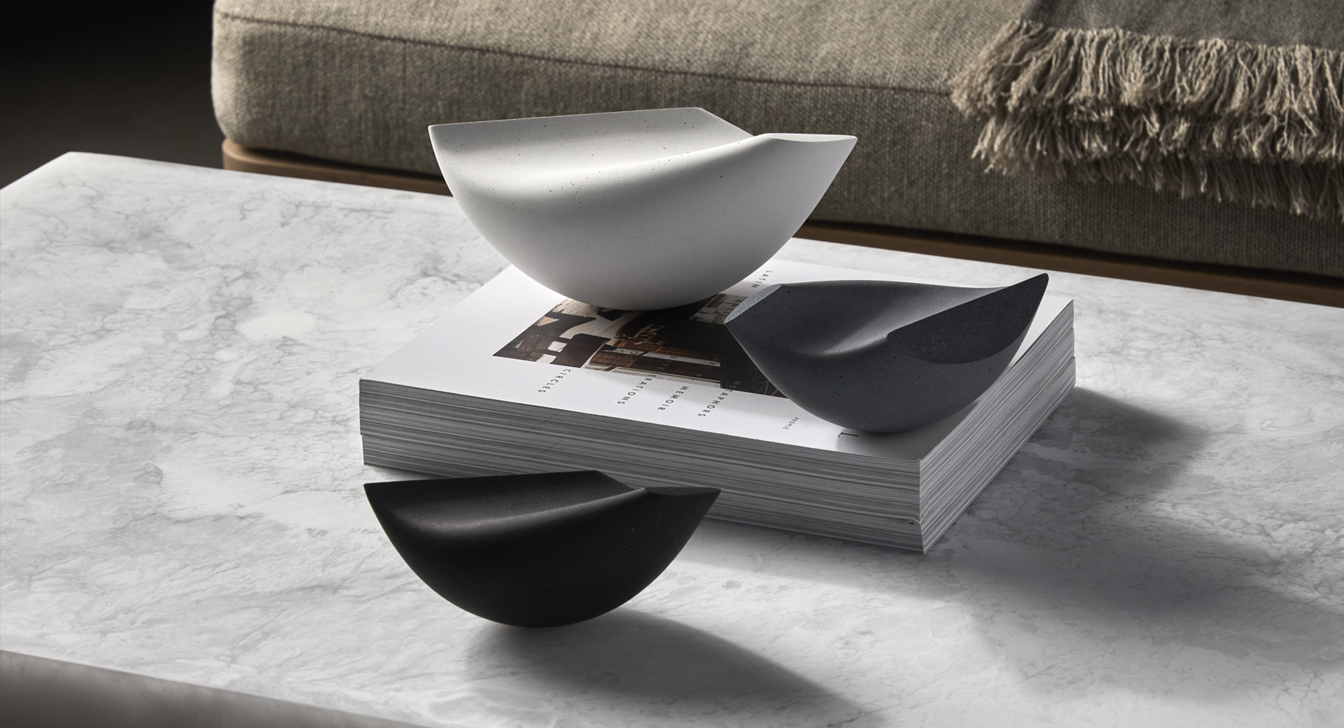 White concrete Oiseau (bird) sculptures on tabletop.