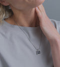 Video of model wearing Memento Mindful pendent with concrete set into small square stainless steel design.