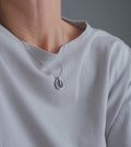 Video of model wearing Memento Eternal pendent with concrete set into small circular stainless steel design.