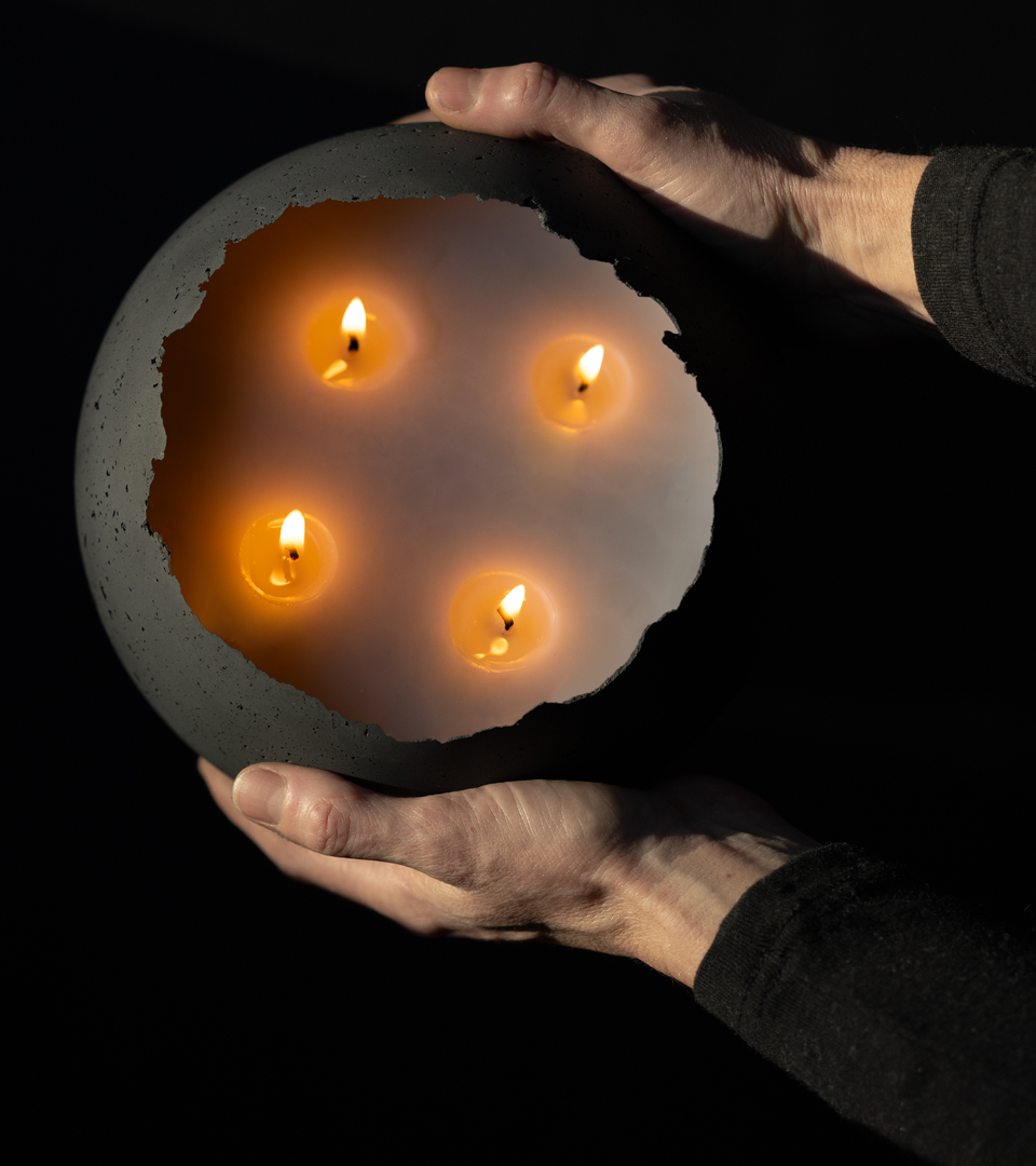 Birdseye view of hands holding extra large, 4 wick concrete candle.