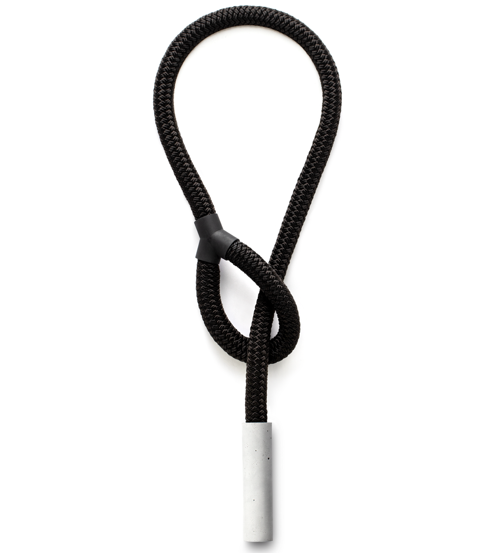 Form a necklace by threading the loop of this black double-braided rope with a natural concrete pillar.