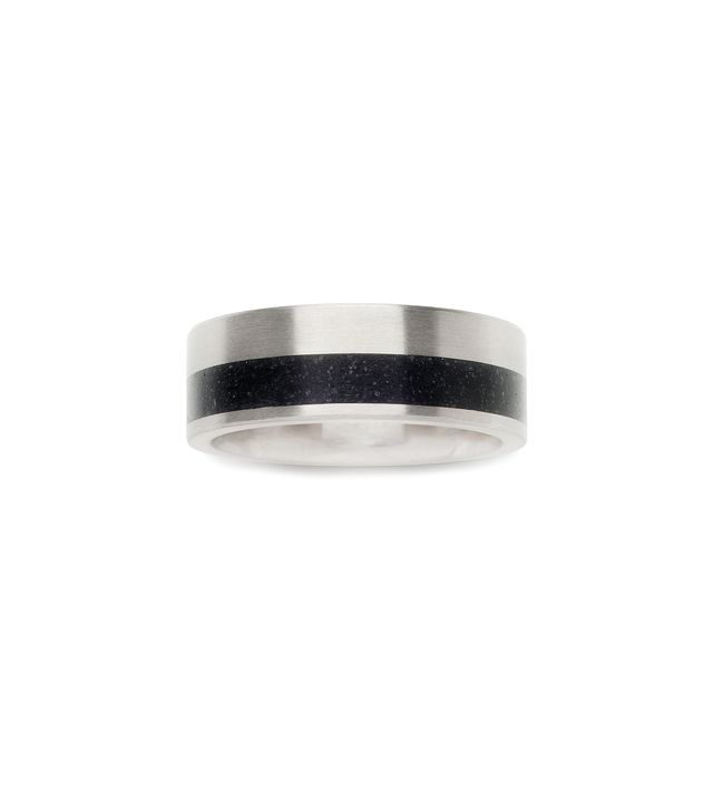 Minimalist black concrete ring off set between stainless steel bands. Top view.