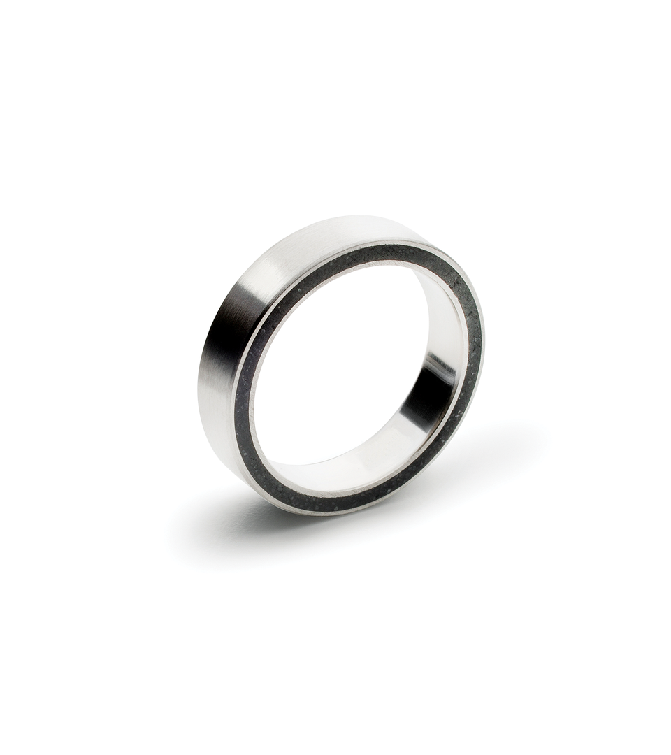 Minimalist stainless steel band designed with black concrete cast into the side. 