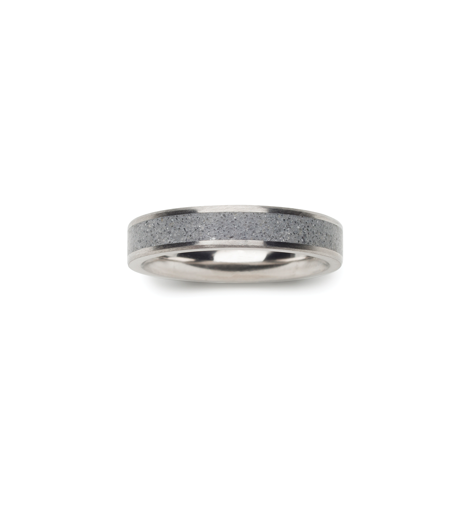 Birds eye view of thin concrete and stainless wedding ring.