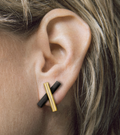 Close up of model wearing fashionable 14k gold and concrete earring studs.