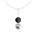 The Freya statement necklace features two double stainless steel larger domes, one lined with diamond dust infused black concrete both architecturally supported an elegant hanging steel post.