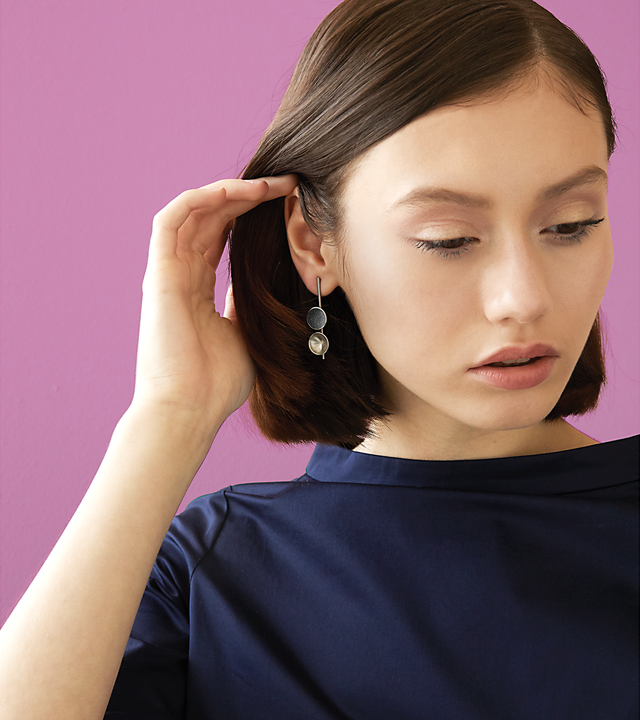 Bauhaus inspired Freya Minor earrings feature two smaller double stainless steel domes, one lined with diamond dust infused black concrete both architecturally supported an elegant hanging steel post.