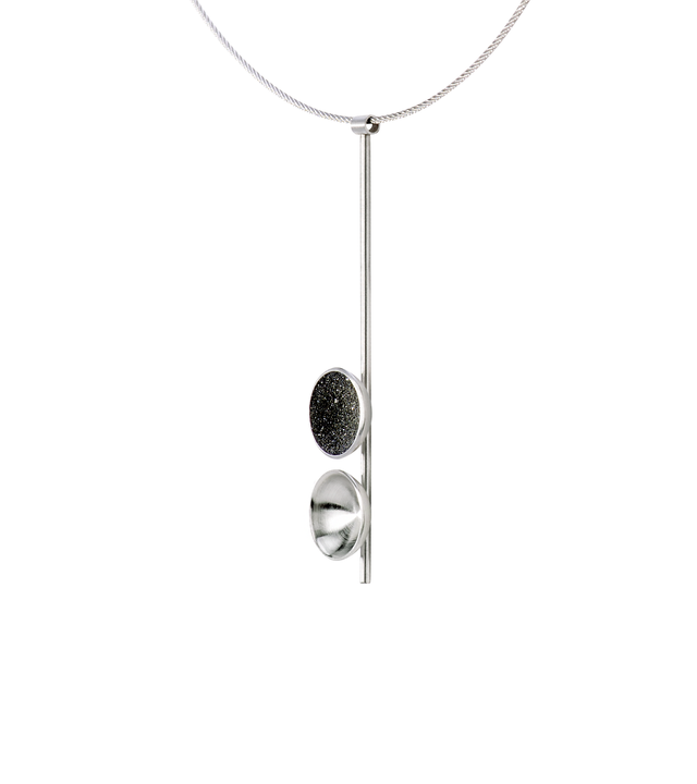 Side view of the Freya Minor modern necklace features two double stainless steel domes, one lined with diamond dust infused black concrete both architecturally supported an elegant hanging steel post.