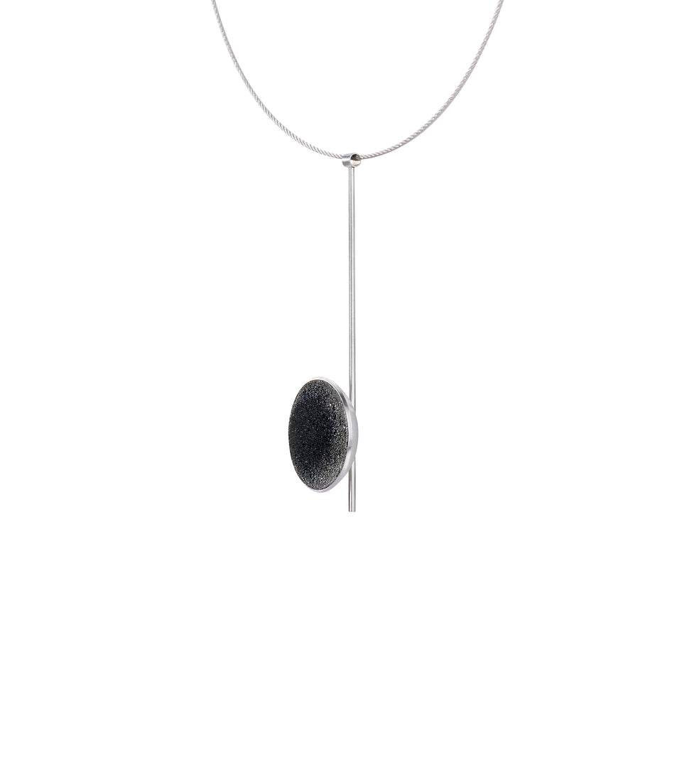 Side view of the Inspira necklace featuring authentic diamond dust embedded into a concrete lined shallow stainless steel dome architecturally positioned onto a suspended minimalist steel post. 