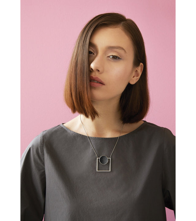 Continuum necklace combines the geometry of a smaller stainless steel dome lined with the sparkle of diamond dust encrusted concrete suspended onto a minimalist steel square frame.