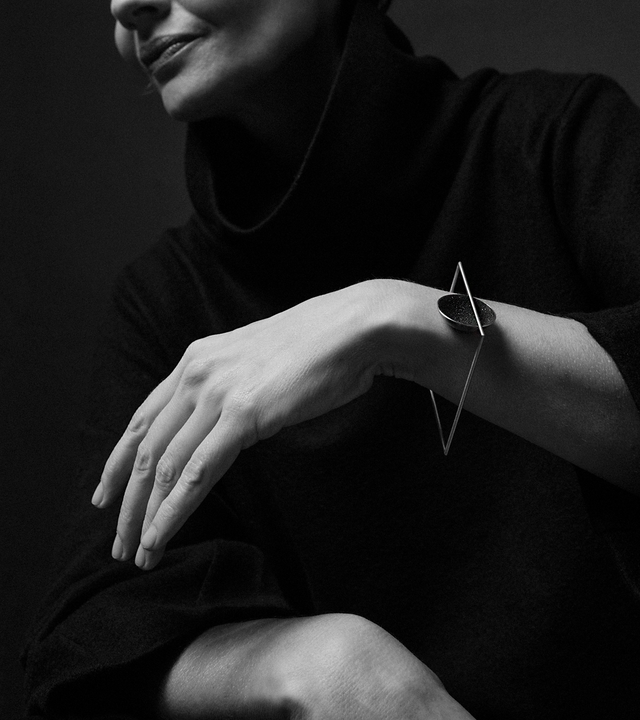 The Frama Minor bracelet is Bauhaus design inspired jewelry featuring diamond dust infused black concrete set into a small stainless steel dome suspended from a square steel frame.