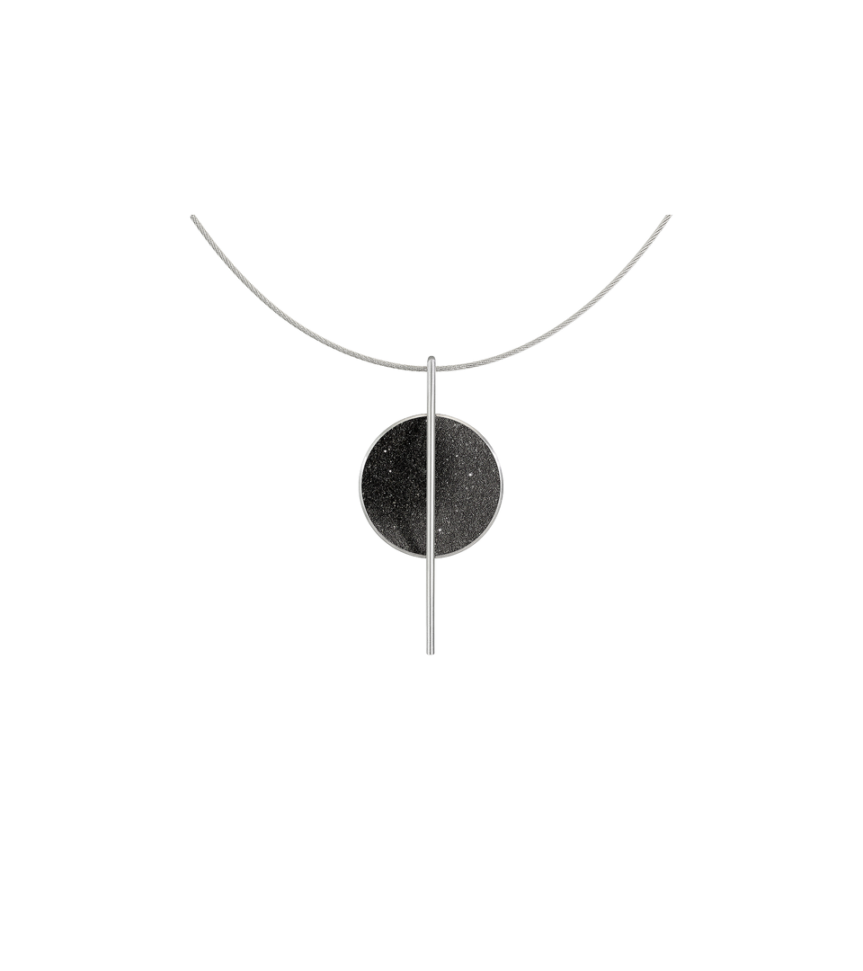 The Linnea necklace features black concrete and the sparkle of embedded diamond dust set into a stainless steel dome suspended from a steel post and hung by a stainless cable.