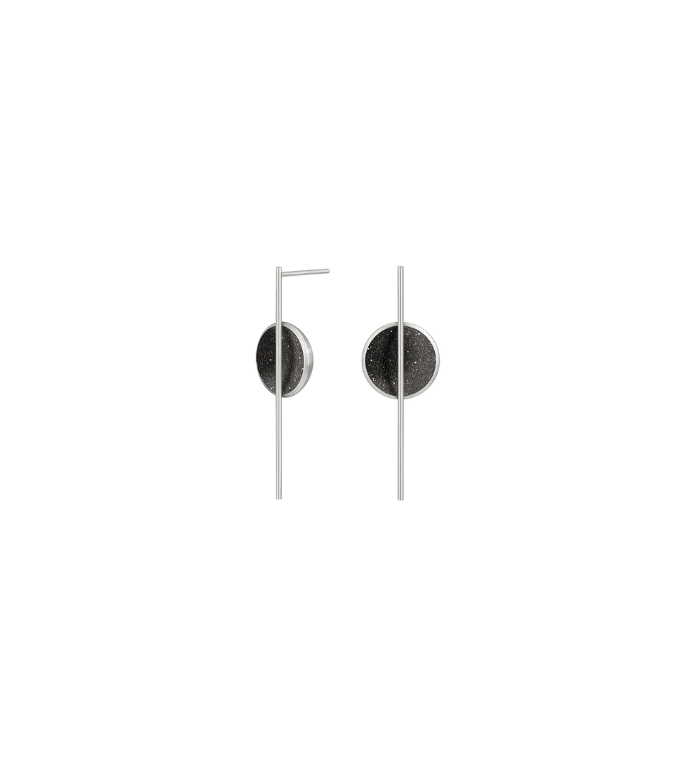 The minimalist earrings Linnea Minor sparkle with diamond dust and black concrete set into a stainless steel dome architecturally suspended from an elegant steel post. 