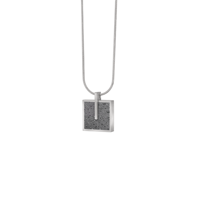 Three-quarter view of Memento Mindful pendent with concrete set into small square stainless steel design.