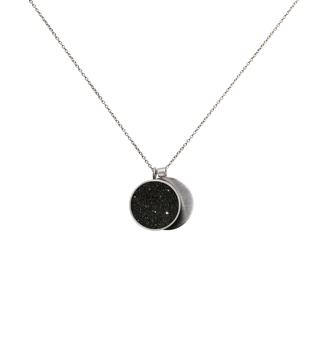 This minimalist overlapping double pendant in concrete, diamond dust and stainless steel hangs from a linked necklace chain.
