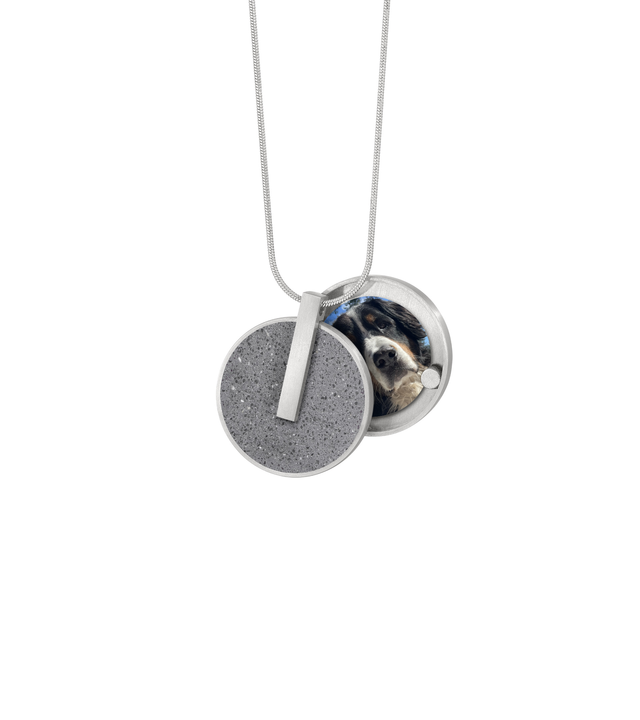 Memento, eternal locket set with natural concrete open to show photo of loved one inside.