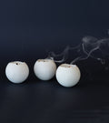 White concrete tealight candles photographed on black.