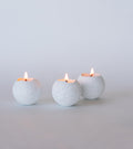 Set of 3 white orbed concrete tealight candles.